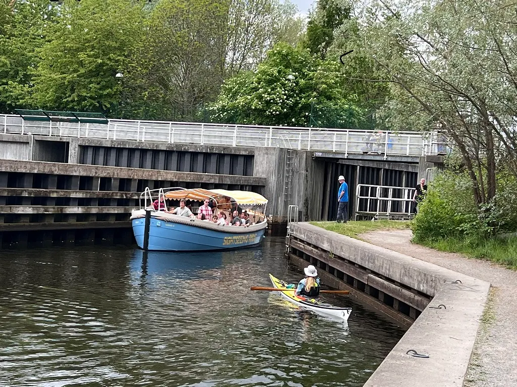 Sightseeing Rides blå eldrivna båt med gäster i Sicklaslussen